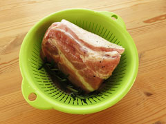 豚肩ロースのブロック肉をブライン液ごとザル付きのボウルに入れる。
