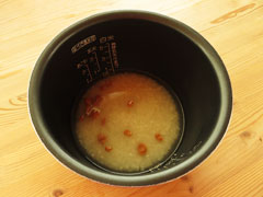 炊飯器の内釜に炒めた米と鶏がらスープの素を溶かした水を入れる。