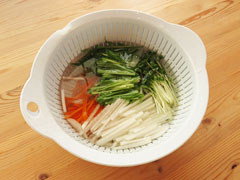 切り分けた野菜が入ったボウルに冷水を注ぐ。