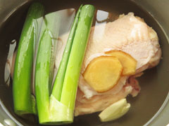 鶏むね肉とネギの青いところ、生姜、にんにくを入れた鍋に、塩と砂糖、酒、水を入れる。