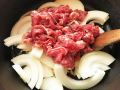 にんにくを炒めている鍋に牛肉と玉ねぎを入れる。