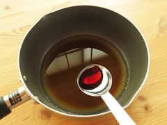だし汁の入った鍋に醤油を加える。