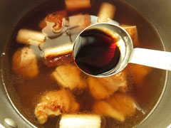 だし汁を煮込んでいる鍋に醤油を加える。