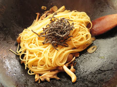 しめじと舞茸を炒めているフライパンに、茹で上がったスパゲティと塩昆布、スパゲティの茹で汁お玉半分を入れる。