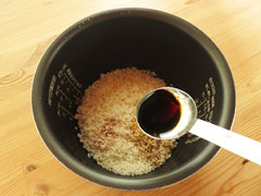米の入った炊飯器の内釜に、醤油を加える。