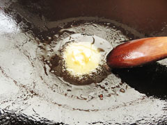 ウインナーと玉ねぎを炒めたフライパンに、バターを入れる。
