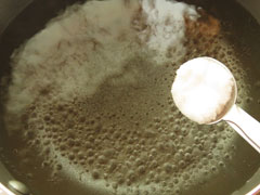 鍋で沸かしている水に塩を入れる。