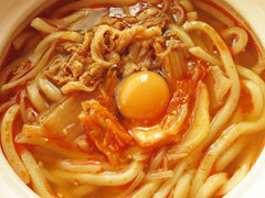 豚キムチ煮込みうどんに生卵を落とす