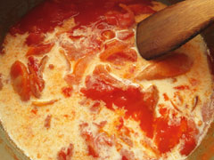 トマトを煮込んでいる鍋に牛乳を入れる。
