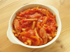 グラタン皿にトマトソースで煮込んだマカロニを盛り付ける。