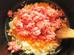 にんにくを炒めている鍋に、みじん切りにした野菜と合いびき肉を入れる。