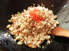 具を炒めているフライパンに、ひき肉と混ぜたご飯と紅しょうがを入れる。。