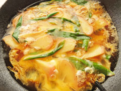 カマボコとネギを煮ているフライパンに、溶き卵3/2を入れる。
