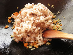 野菜を炒めているフライパンに、ひき肉と混ぜ合わせたごはんを入れる。