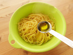 茹でたスパゲティにオリーブオイルを回しかける。