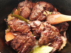 野菜を炒めている鍋に牛すね肉とローリエを戻す。