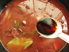 漬け込みに使った赤ワインとトマトジュース、水を注いだ鍋に、醤油を加える。
