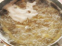 手打ちうどんをたっぷりの沸騰した湯で茹でる。