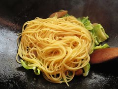 具を炒めているフライパンに茹でたスパゲティを加える。