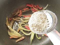 ベーコンと玉ねぎを炒めている鍋に、小麦粉を加える。
