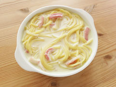 ソースとからめたスパゲティをグラタン皿に盛り付ける。
