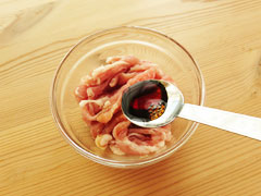 小皿に入った豚肉に、しょうが焼きのたれ小さじ1を加える。