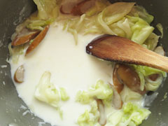 具材と小麦粉を炒めた鍋に、牛乳を少量注ぐ。