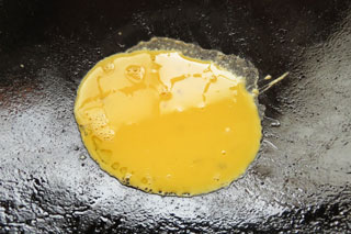 中火で熱したフライパンに、溶き卵を入れる。