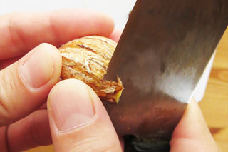 栗の渋皮を包丁で切る。