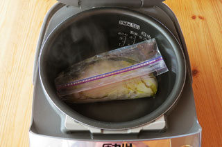 湯を入れた炊飯器の内釜に、鶏むね肉の入ったジップロックを入れる。