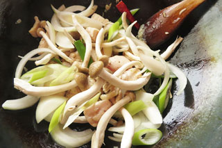 鶏むね肉を炒めているフライパンに、切り分けた野菜を入れる。