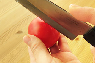 包丁でトマトに切れ込みを入れる。