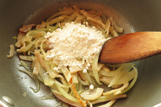 ベーコンと玉ねぎを炒めている鍋に小麦粉を加える。