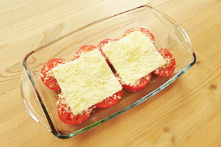 スライスチーズをのせ、パン粉とパルメザンチーズをちらした輪切りのトマト。