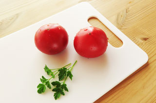 分量の目安。まな板の乗ったトマト2個とイタリアンパセリ
