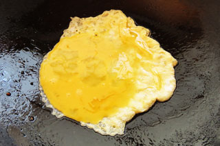 中火で熱したフライパンに溶き卵を入れる。