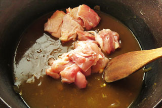 温めているカレーの入った鍋に、ひと口大に切り分けた鶏もも肉を入れる。
