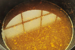 残りカレーの入った鍋に水とめんつゆをくわえる。