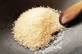 鶏の脂が入ったフライパンに生米を入れる。