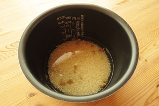 炊飯器の内釜に炒めた米と水を入れる。