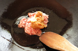 中火で熱した鍋に豚ひき肉とにんにく、みりん、砂糖、すりごまを入れる。