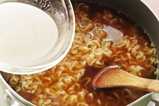 インスタントラーメンを作っている鍋に、水溶き片栗粉をくわえる。