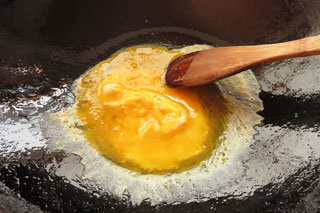 中火で熱したフライパンに溶き卵を入れる。