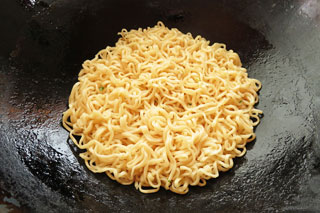 サラダ油を入れて中火で熱したフライパンに、ゆであがったインスタントラーメンの麺を入れて焼く。