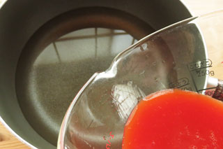 水を入れた鍋にトマトジュースを注ぐ。