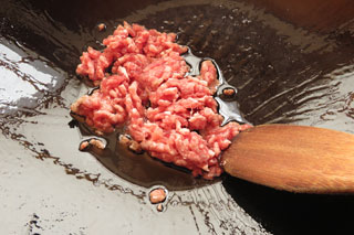 サラダ油を入れて中火で熱したフライパンにひき肉を入れる。