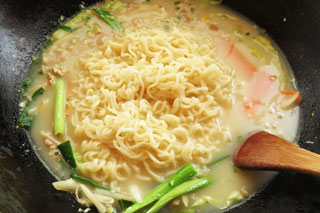 長崎ちゃんぽんのスープを煮込んでいるフライパンにインスタントラーメンの麺を入れる。