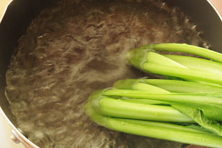 沸騰している湯に小松菜の根元側を入れる。