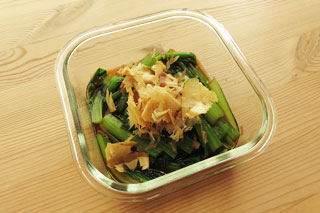容器に入れて出汁醤油をかけた小松菜に、かつおぶしをふりかける。