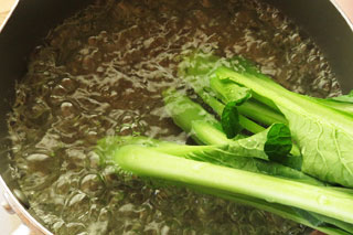 沸騰している湯に小松菜の根元側を入れる。